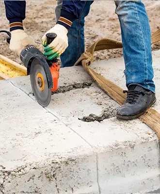 Worker using a specialized circular saw to cut through concrete.