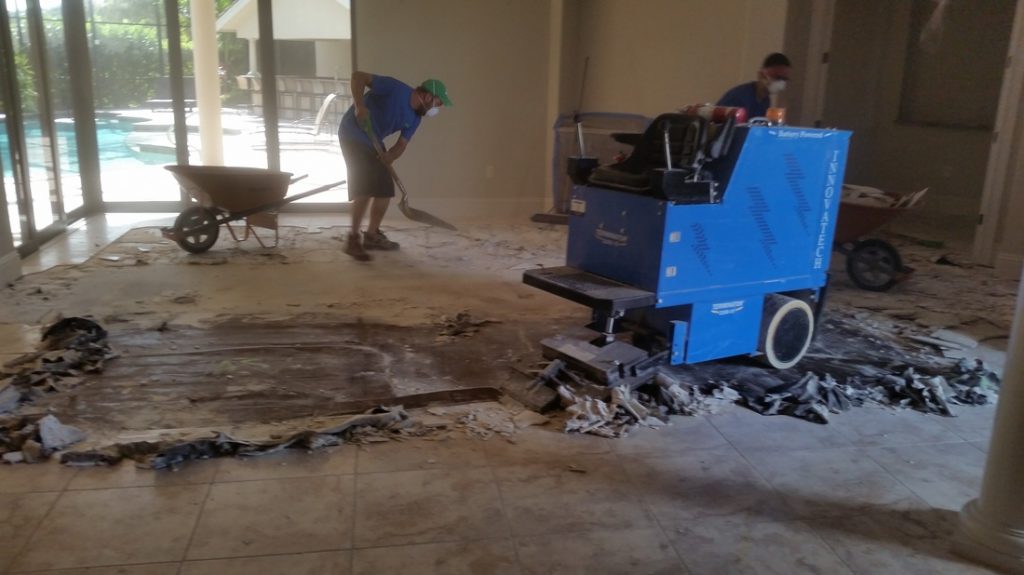 Eco Demolitions employees working on a residential job site to remove the flooring from a living room.