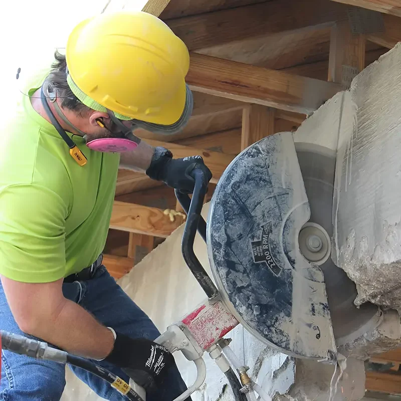 Eco Demolitions employee performing a concrete cutting service on a building.